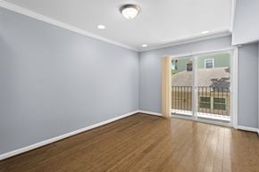 Washington apartment for rent - a bedroom with a sliding glass door and hardwood floors